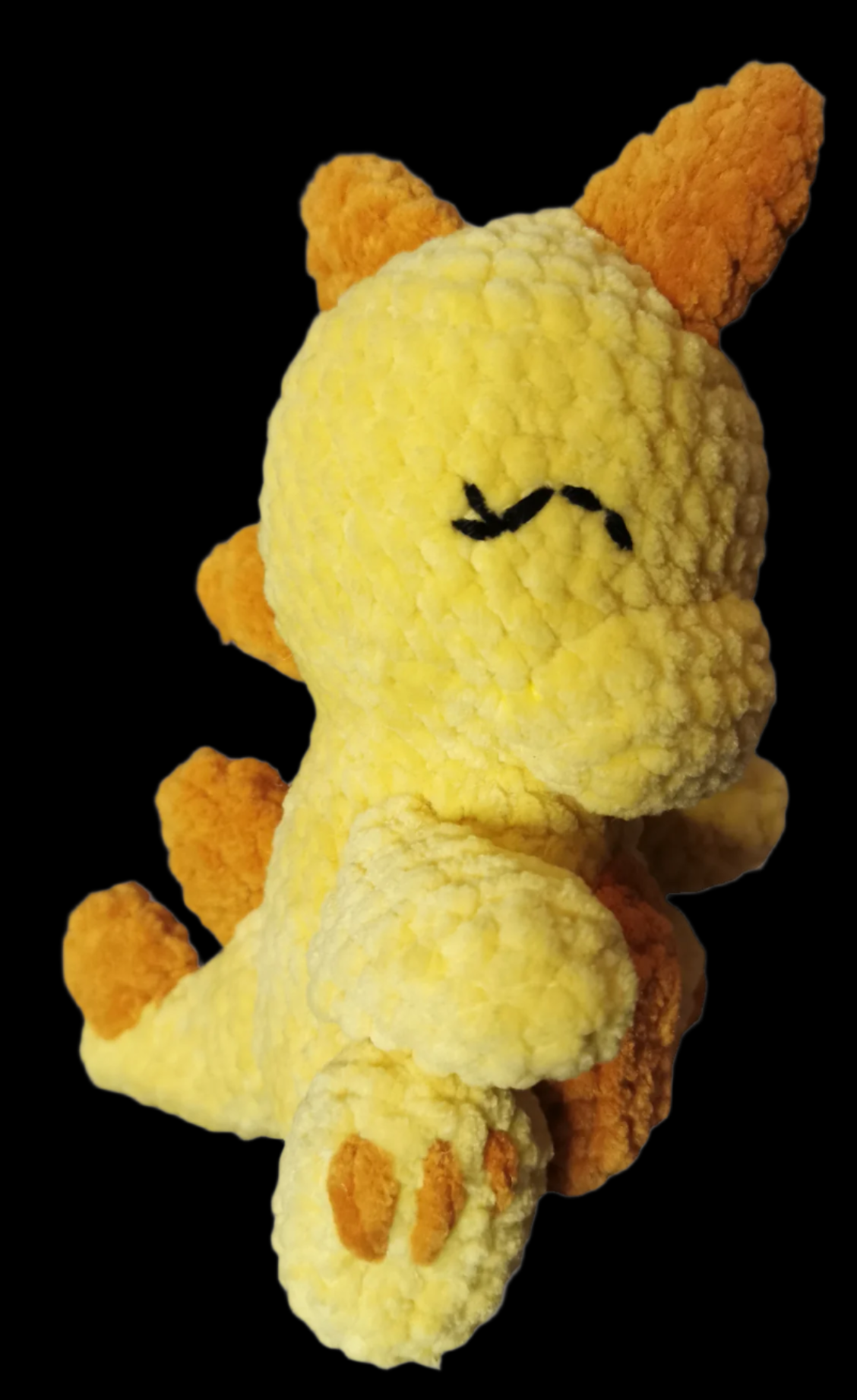 A yellow crocheted Gigantosaurus soft toy