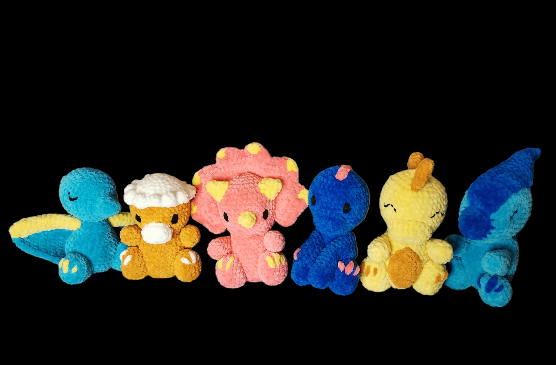 6 crocheted dinosaur soft toys lined up in a row